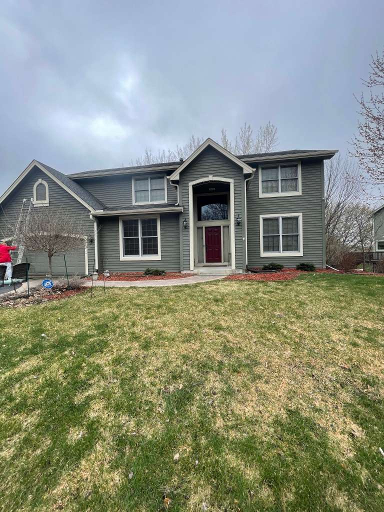 Gray green home with red door after painting